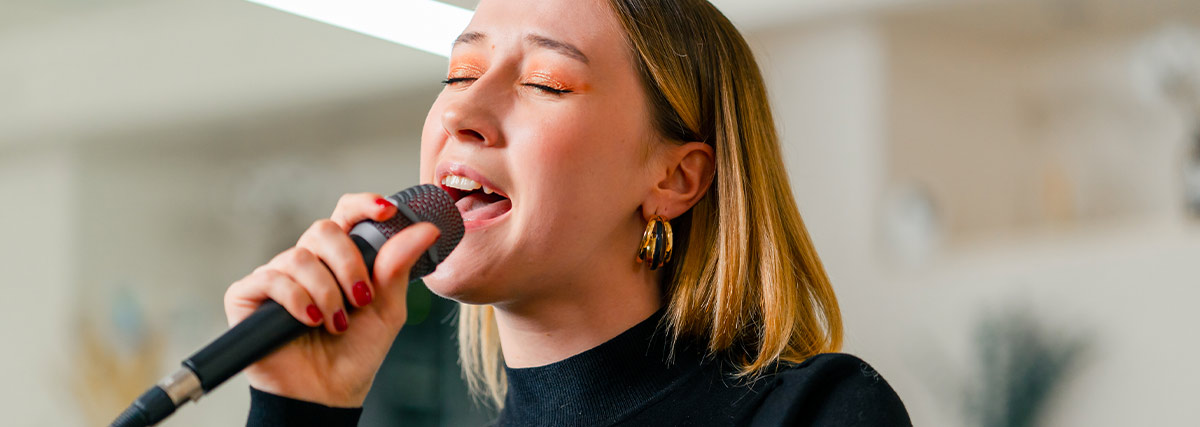 Adult singing student developing vocal range with a microphone