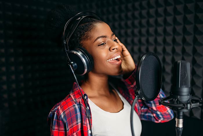 female singer in studio singing feat