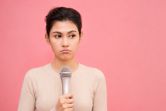 Female singer with microphone feeling sad to sing