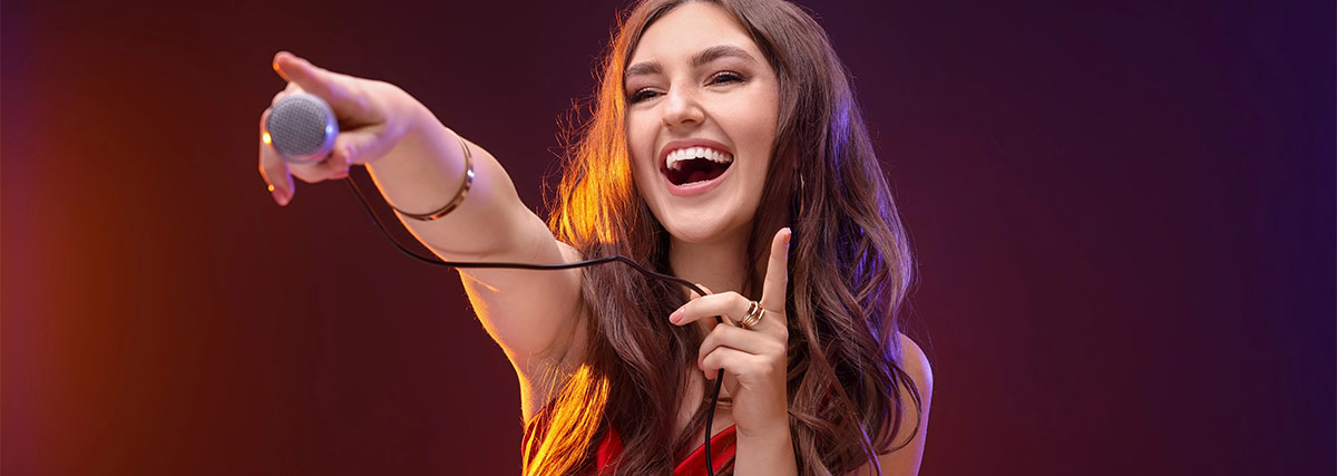 Happy woman holding a microphone and pointing