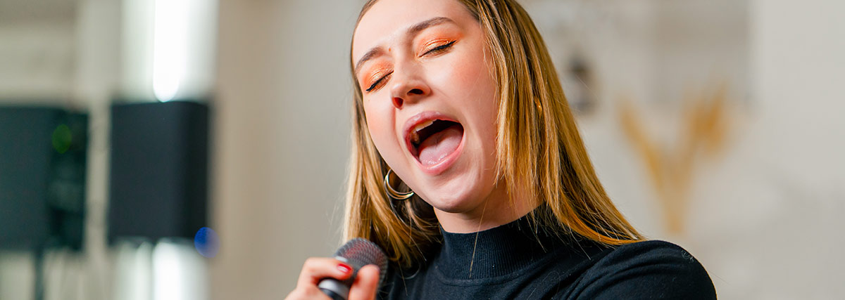 Lady hitting high notes with close eyes