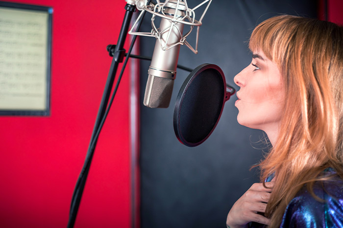 Lady with blue dress singing in studio