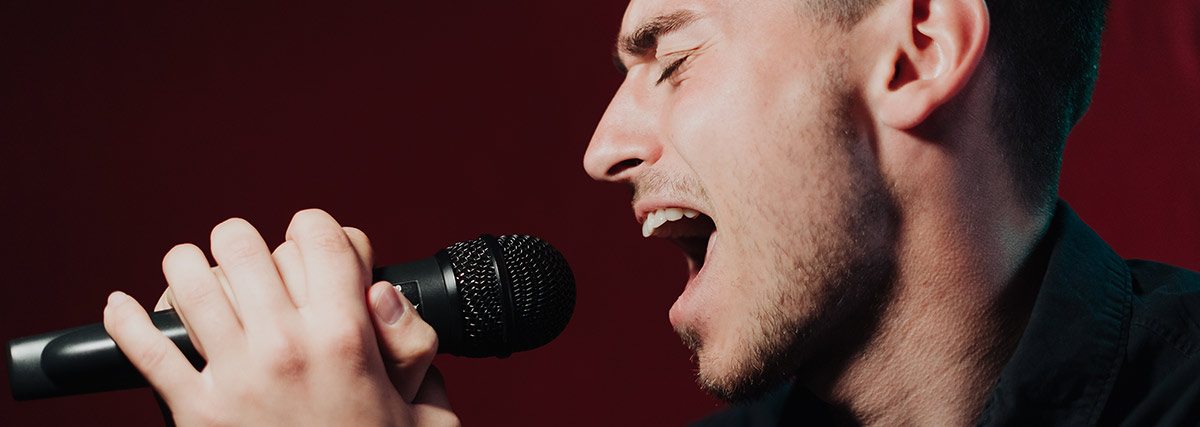 Male singer performing into a microphone during a vocal performance