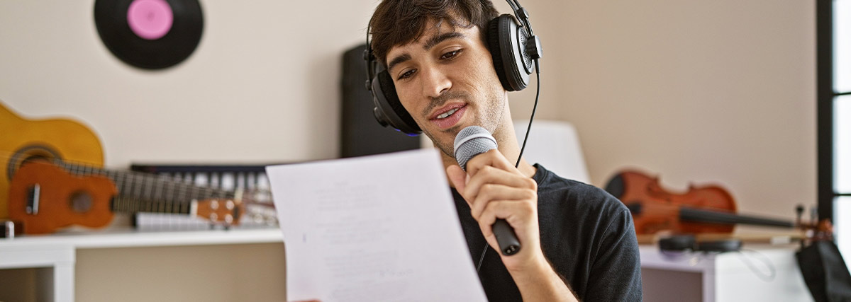 Man holding microphone reading music lyrics in the studio