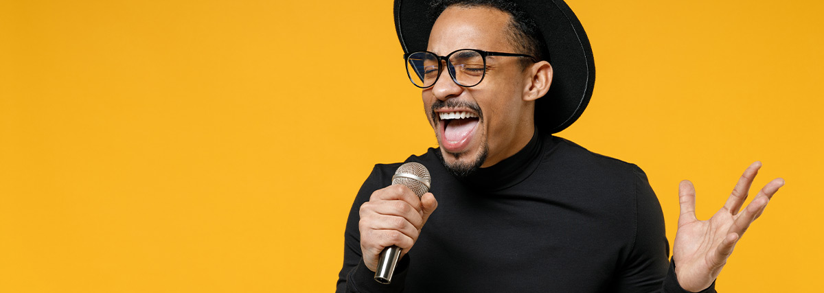 Man singing against yellow background