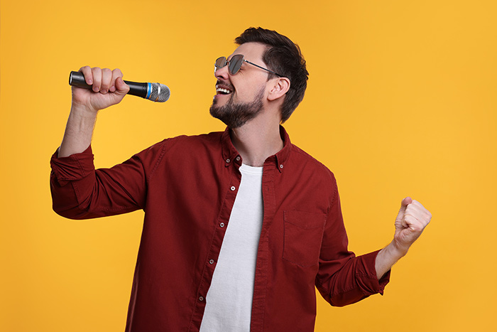 Man wearing sunglasses singing feat