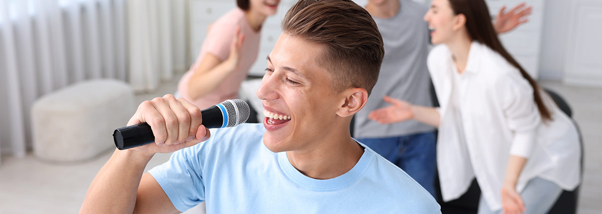 Man with blue shirt smiling and singing