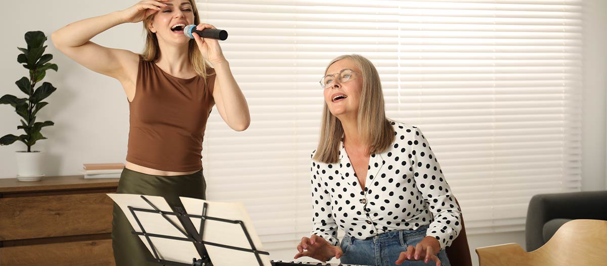 One woman singing and another playing keyboard