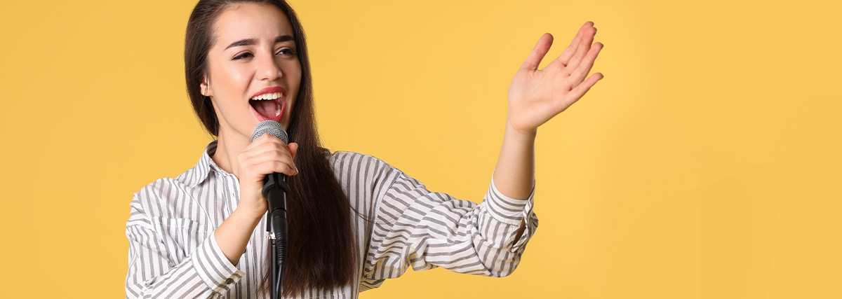 Singer performing with microphone in yellow backgroud