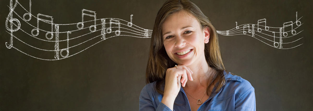 Teacher smiling with chalk board background