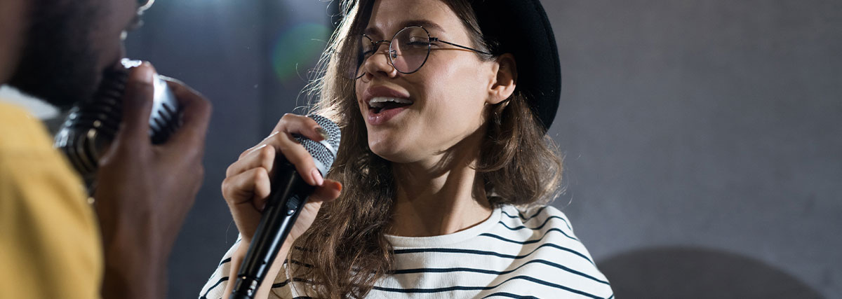 Vocalist singing with microphone during duet practice and ear training session