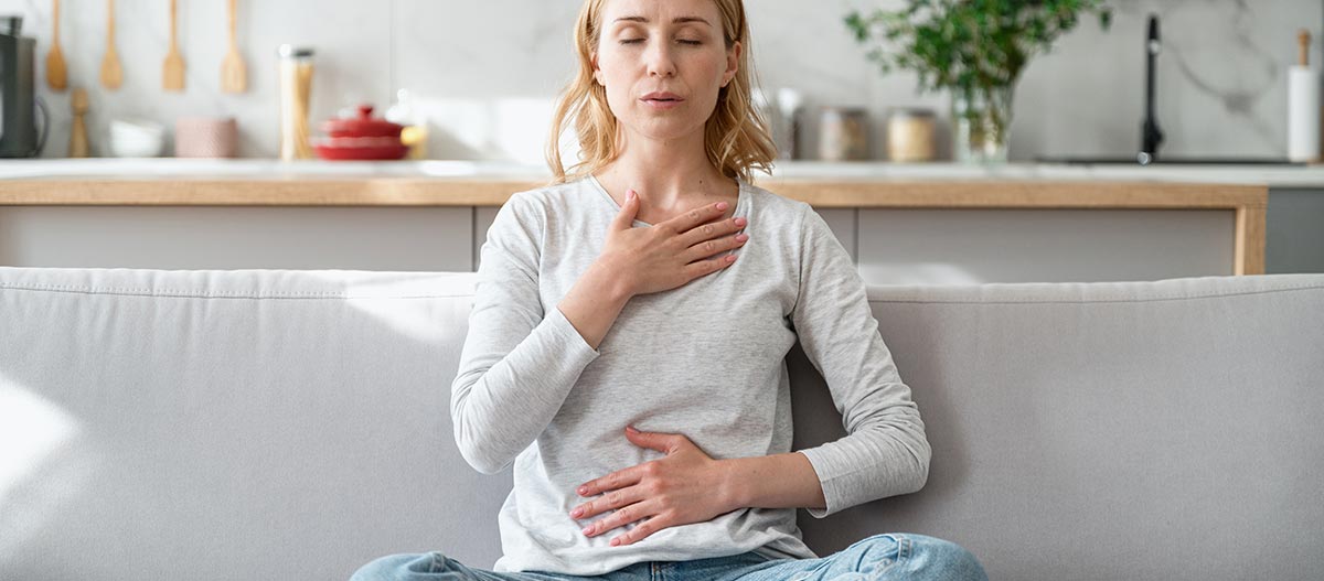Woman holding chest and stomach doing breathing exercise