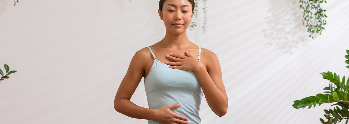 Woman holdng her stomach and neck practising breathing