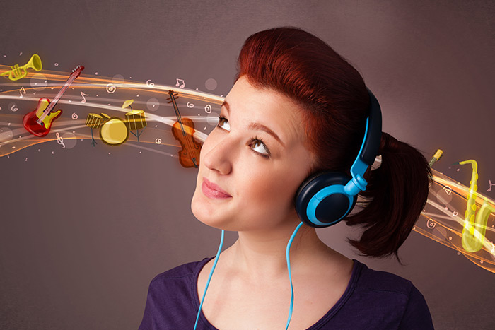 Woman listening to music with headphones and imagining musical sounds for audiation training