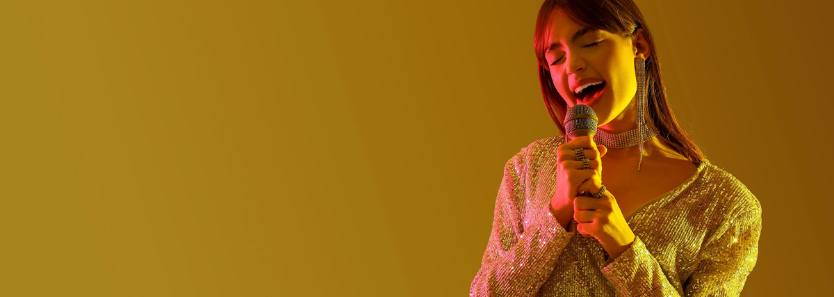 Woman singing against yellow color background
