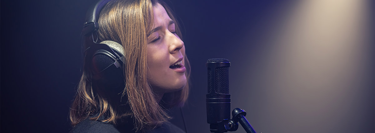 Woman with headphones on singing passionately