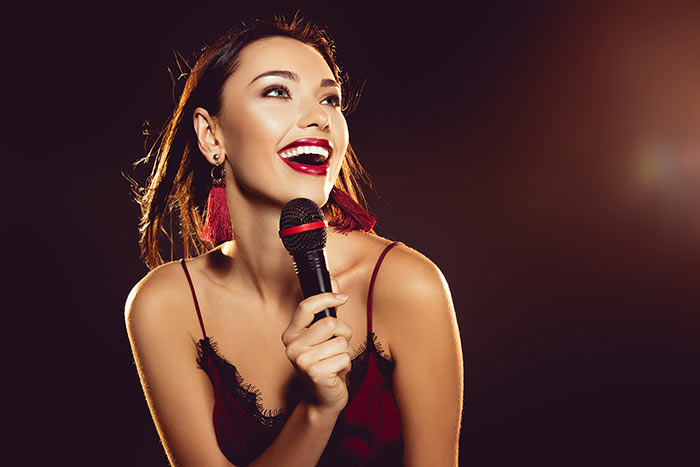 woman in red singing feat