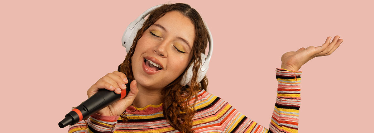 Young singer practising with headphones and microphone for vocal development